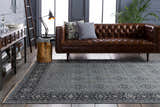 Living room scene with a brown leather sofa and a blue Sherwood Area Rug with a traditional pattern. Roomscene-Rectangle