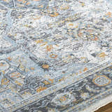 Close-up of the Hovan Area Rug showing its traditional pattern, gray, light blue, and gold colors, and soft texture. Texture