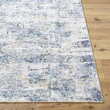 Close-up of the Hyman Area Rug in cloud gray and denim, showing its distressed contemporary design and soft texture. Front