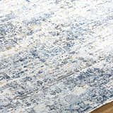 Close-up of the Hyman Area Rug showing its contemporary design with camel, gray, and denim colors. Texture