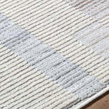 Close up of the Chouko Broken-Striped Area Rug showing beige, brown, and silver gray stripes. Contemporary style. Texture