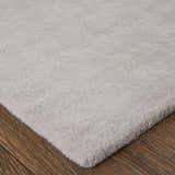 Close-up of the Feizy Anya rug showing its plush, off-white pile and texture on a wood floor. Corner