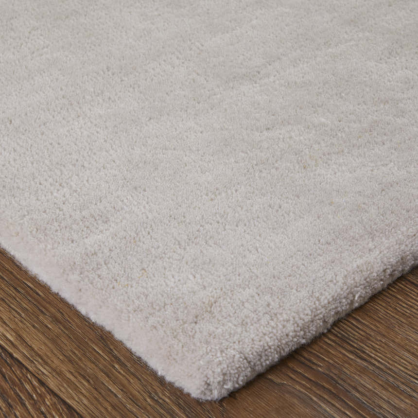 Close-up of the Feizy Anya rug showing its plush, off-white pile and texture on a wood floor. Corner