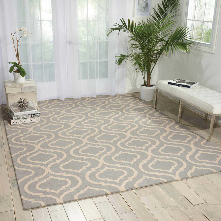 Light, airy room with a Nourison Linear Light Blue Moroccan rug, white bench, plants, and sheer curtains.