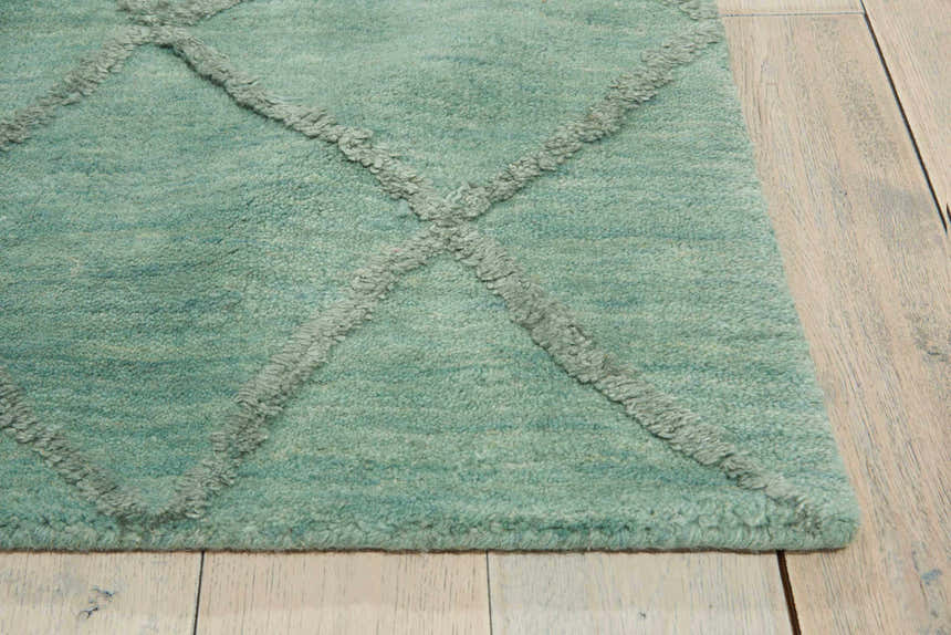 Close up of the aqua Nourison Lunette rug showing wool texture and geometric design.