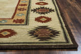 Close-up of the Rizzy SU2015 area rug. Beige wool rug with burgundy, navy, and sage Southwestern pattern on a wood floor. Corner