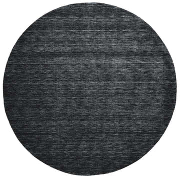 Close-up of a round, black Feizy Luna Area Rug. The hand-woven wool rug has a subtle, contemporary texture. Design-Round