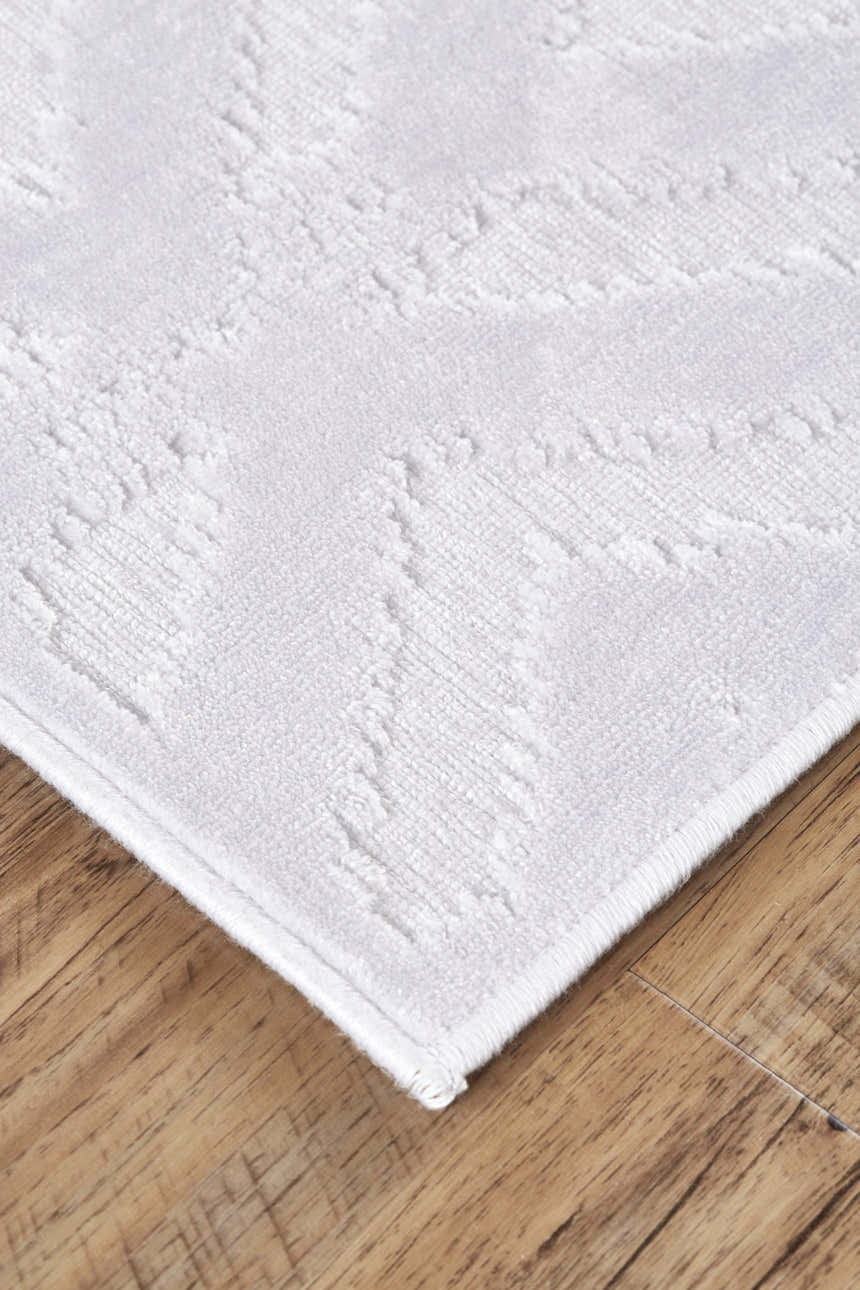 Close up of the Feizy Saphir Mira Modern Solid White Area Rug showing texture and subtle geometric pattern. Corner