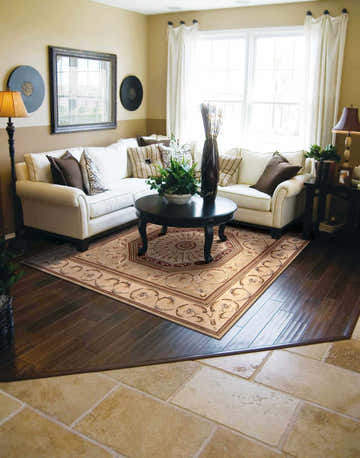 Living room with white sectional and Nourison Versailles Palace Sage Vintage Area Rug.