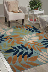 Living room scene with a light blue Nourison Caribbean area rug featuring a contemporary leaf pattern.