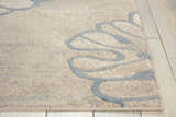 Close-up of the beige Nourison Maxell rug with a raised, swirling gray pattern on a light wood floor.