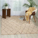 Living room scene with Barclay Butera Intermix Sand Indoor Area Rug, wood chair, side table, and light wood floors.