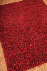 Close-up of a plush, vibrant red Nourison Zen Shag rug. The handmade rug has a deep pile and a soft, inviting texture.