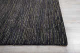 Close-up of the Onyx Nourison OCEAN rug. Black rug with a vertical striped pattern on light gray wood floors.