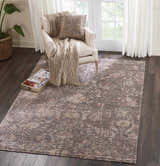 Living room scene with Nourison Lucent Flint Vintage rug, armchair, and dark wood floors. Neutral, cozy aesthetic.
