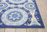 Close-up of Waverly Sun N' Shade Navy rug. Coastal style with blue and white floral medallion pattern. Machine-made texture.