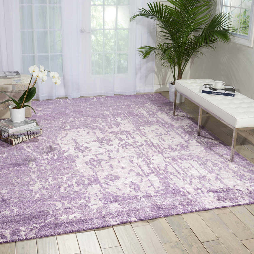 Bright room scene with a Nourison Silk Shadows Amethyst rug, white bench, and indoor plants. Vintage style.