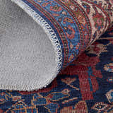 Close-up of Feizy Rawlins rug showing red, blue, and tan oriental pattern and gray cotton backing with stitched edge. Fold