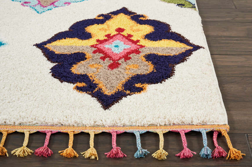 Close-up of Nourison Nomad Ivory Multicolor Floral rug with colorful tassels and a detailed floral pattern.