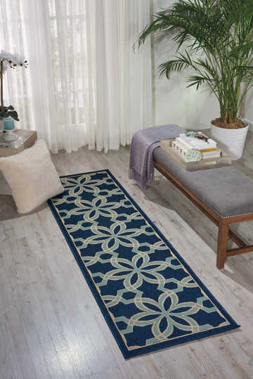Bright entryway with a Nourison Caribbean Navy runner rug, bench, plants, and white curtains.