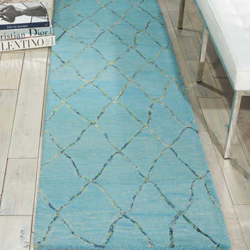 Close-up of the Barclay Butera Intermix Wave rug. The wool rug has a light blue base with a diamond wave pattern.