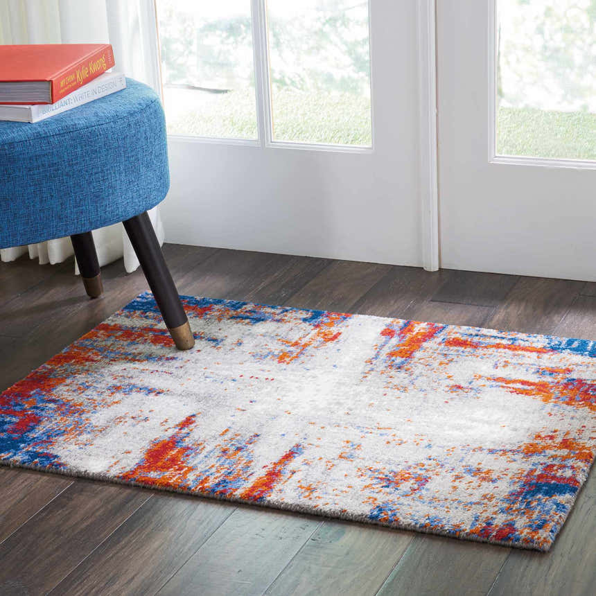 Entryway with Nourison Twilight Ivory Multicolor rug, blue ottoman, and wood floors. Modern style.