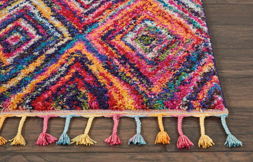Close-up of the Nourison Nomad Red Multicolor Tribal rug, showing the diamond pattern and colorful tassels.