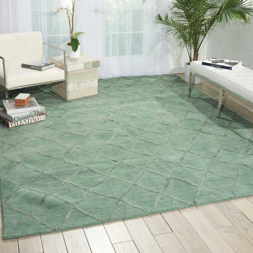 Living room scene with an Aqua Nourison Lunette rug, white chair, bench, and light wood floors.