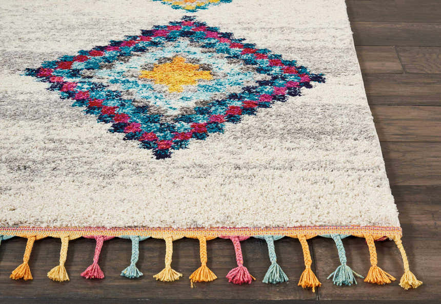 Close up of the Nourison Nomad Cream Grey Tribal Rug, featuring colorful diamond pattern and tassels.