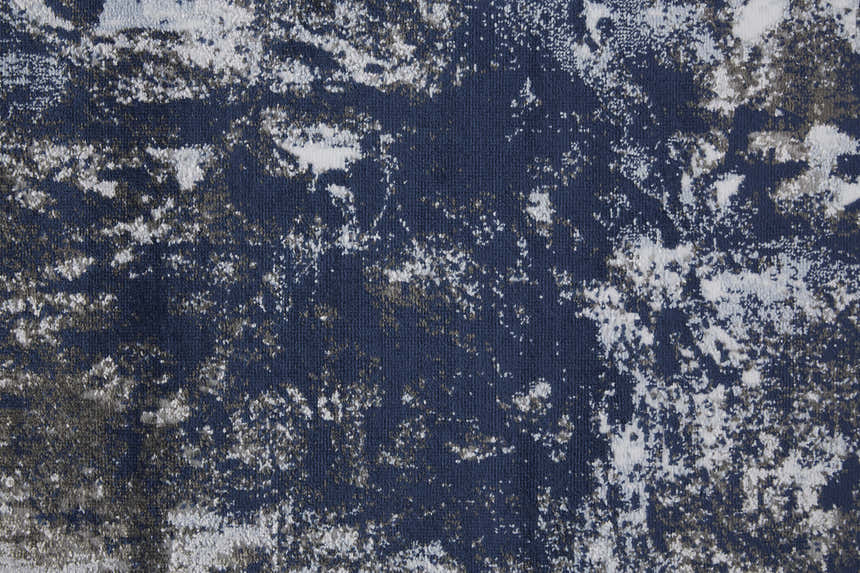 Close-up of the Feizy Gaspar rug. Modern abstract design in blue, gray, and white with a distressed splatter pattern. Texture