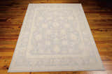 Close-up of the Nourison Zephyr Light Blue rug showing floral pattern and border on hardwood floor.