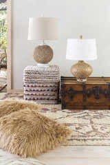 Bohemian living room scene with a Neeses Premium Jute Rug, lamps, and a vintage trunk. Beige, brown, and tan tones create a cozy vibe. Styleshot