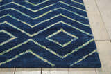 Close-up of the Barclay Butera Intermix Storm area rug. Navy wool rug with a geometric diamond pattern.