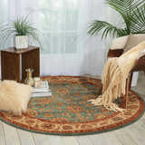 Living room scene with aqua Nourison Living Treasures rug. Round rug features traditional floral pattern in aqua, red, and beige.