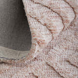 Close-up of the Feizy Colton Modern Diamond rug in pink and ivory, showing its plush texture and geometric design. Fold