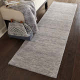 Hallway scene with a Nourison Weston Silver Birch runner rug on dark wood floors, styled with a bench and patterned tote.
