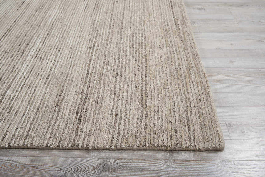 Close-up of the Nourison OCEAN Sand area rug, showing its textured, striated design and sandstone color.