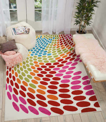 Bright room scene with Nourison Oakdale White/Multicolor rug. Colorful oval pattern on a white rug, with a bench and fluffy ottoman.