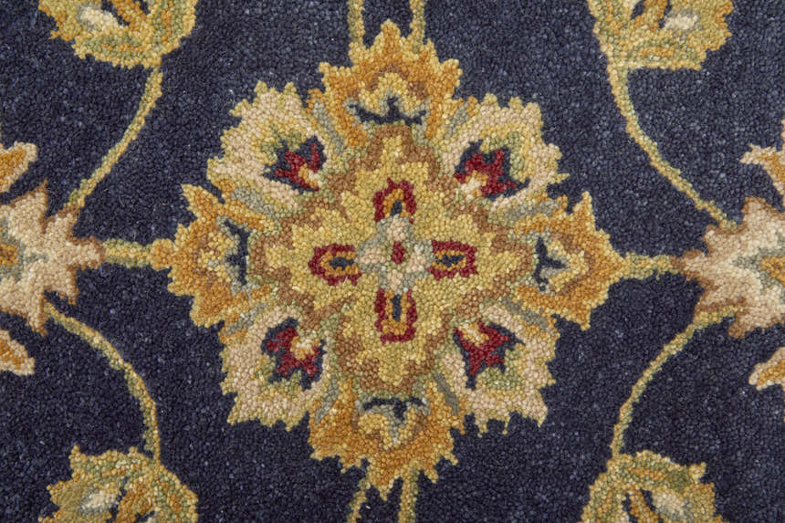 Close up of the Feizy Wagner rug showing the blue, gold, and red traditional floral pattern. Texture