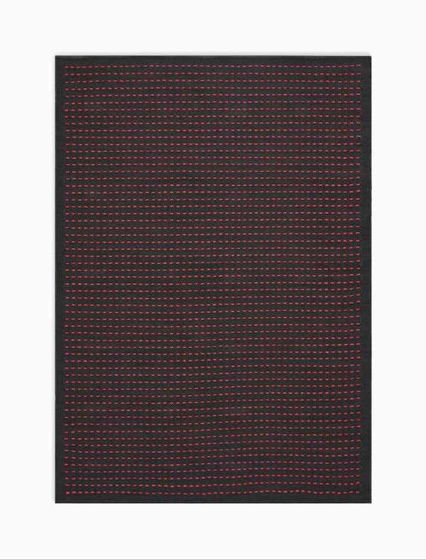 Close-up of the Calvin Klein Seattle Black Magenta rug, featuring a grid pattern of magenta dots on a black background.