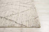 Close-up of the Nourison OCEAN Stone rug showing its chunky texture and sandstone color on wood floors.