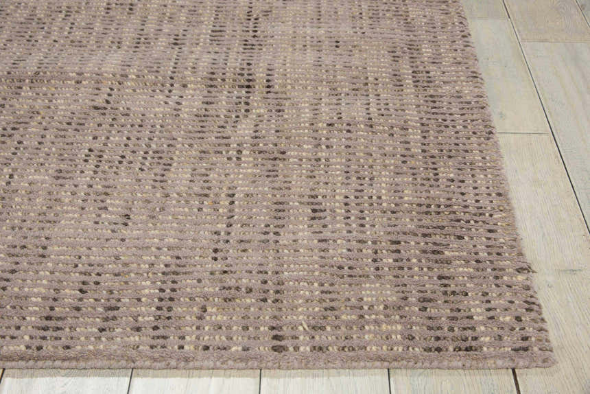 Close-up of the handmade Barclay Butera Intermix Smoke area rug. Gray wool rug with a subtle textured pattern.