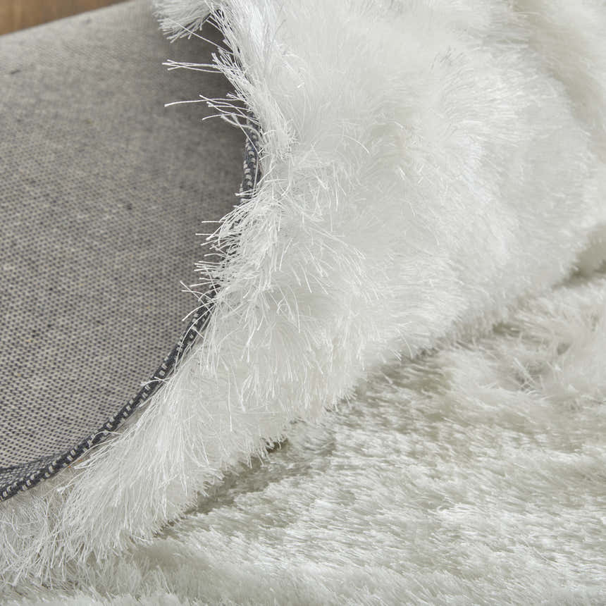 Close-up of the plush, white Feizy Indochine rug showing texture and backing. Fold