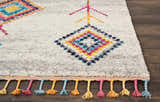 Close-up of the Nourison Nomad Cream Grey Tribal Rug, featuring colorful geometric patterns and playful tassels.