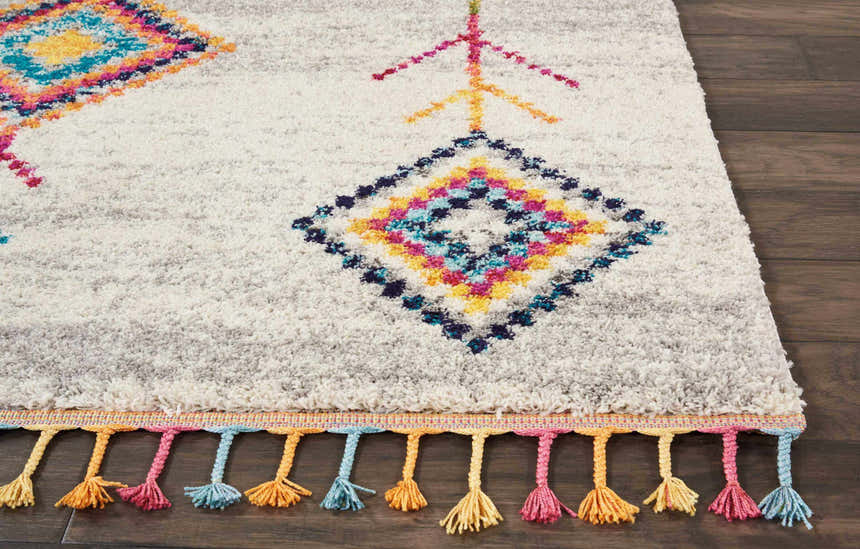 Close-up of the Nourison Nomad Cream Grey Tribal Rug, featuring colorful geometric patterns and playful tassels.