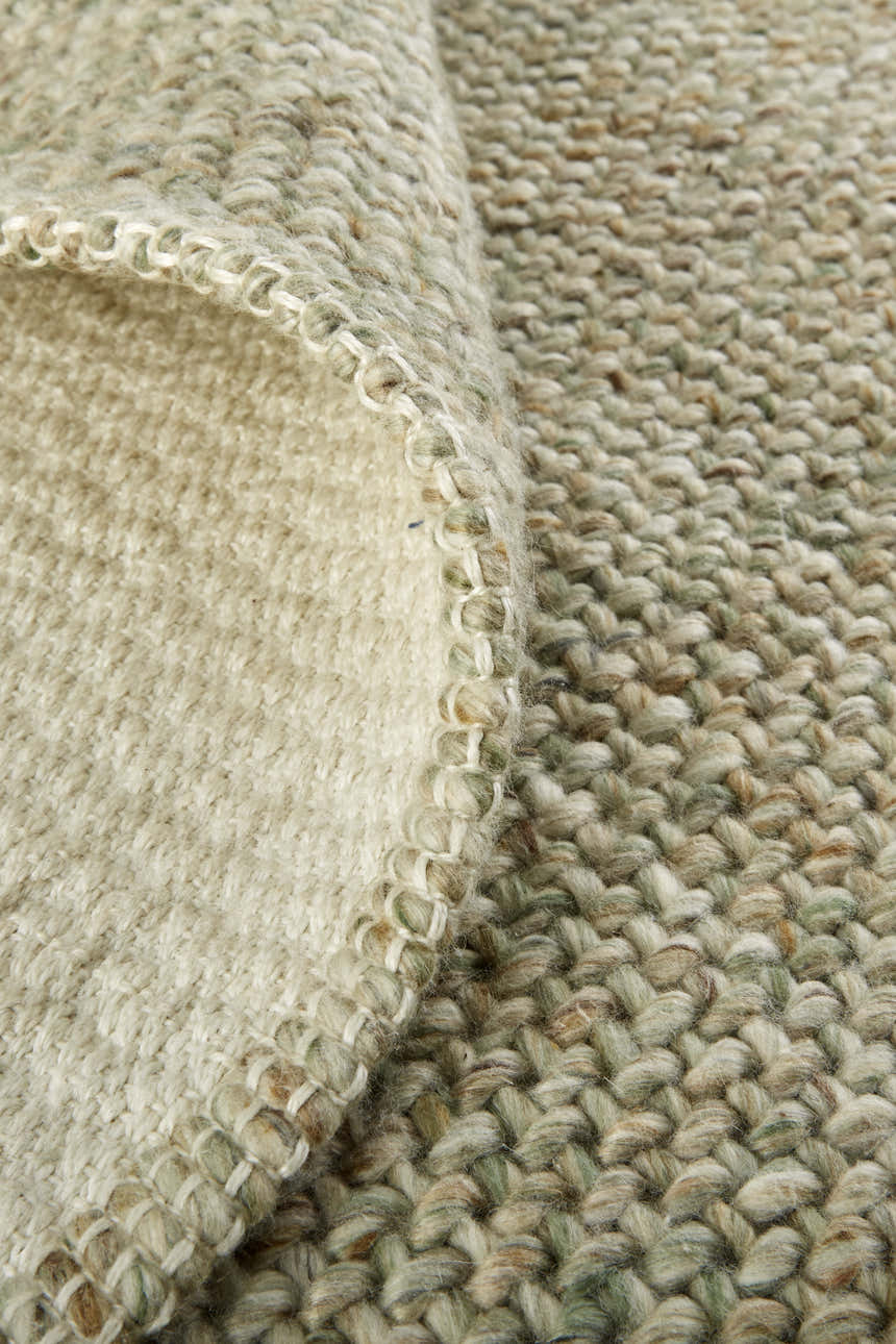Close-up of the hand-woven Feizy Naples Green/Tan Area Rug showing texture and detail. Polyester rug with casual style. Fold