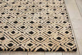 Close-up of the Nourison Deco Mod Black Beige rug, featuring a geometric diamond pattern and textured polyester pile.
