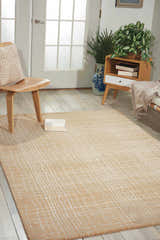 Entryway with a Nourison Nepal Manilla vintage rug, light wood chair, and neutral decor.