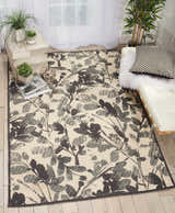 Light-filled room with Waverly Vintage Lux Graphite rug, white daybed, wood floors, and plants. Modern, airy feel.