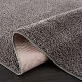 Close-up of the Judy Solid Dark Gray Washable Shag Rug showing its soft texture and durable backing. Fold